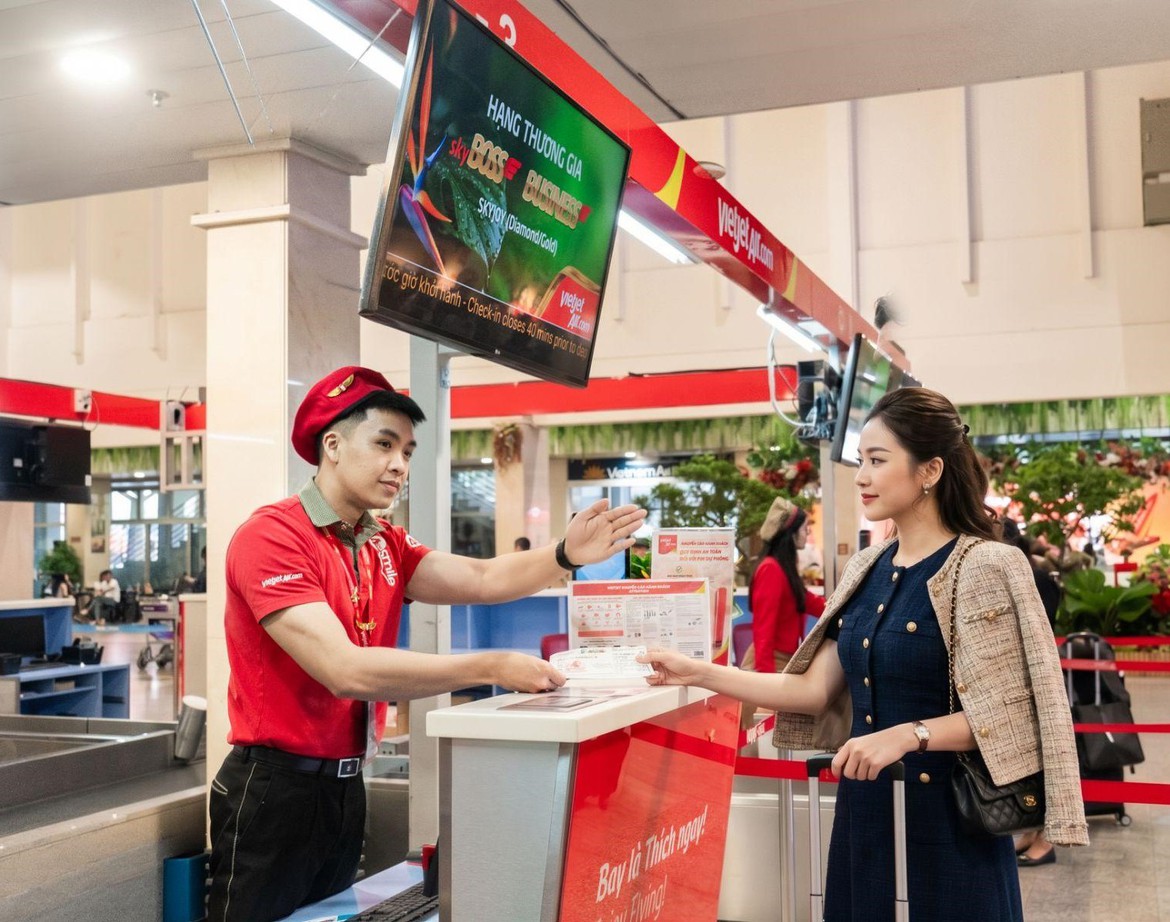 Nhân viên Vietjet hỗ trợ hành khách tại quầy làm thủ tục ở sân bay.