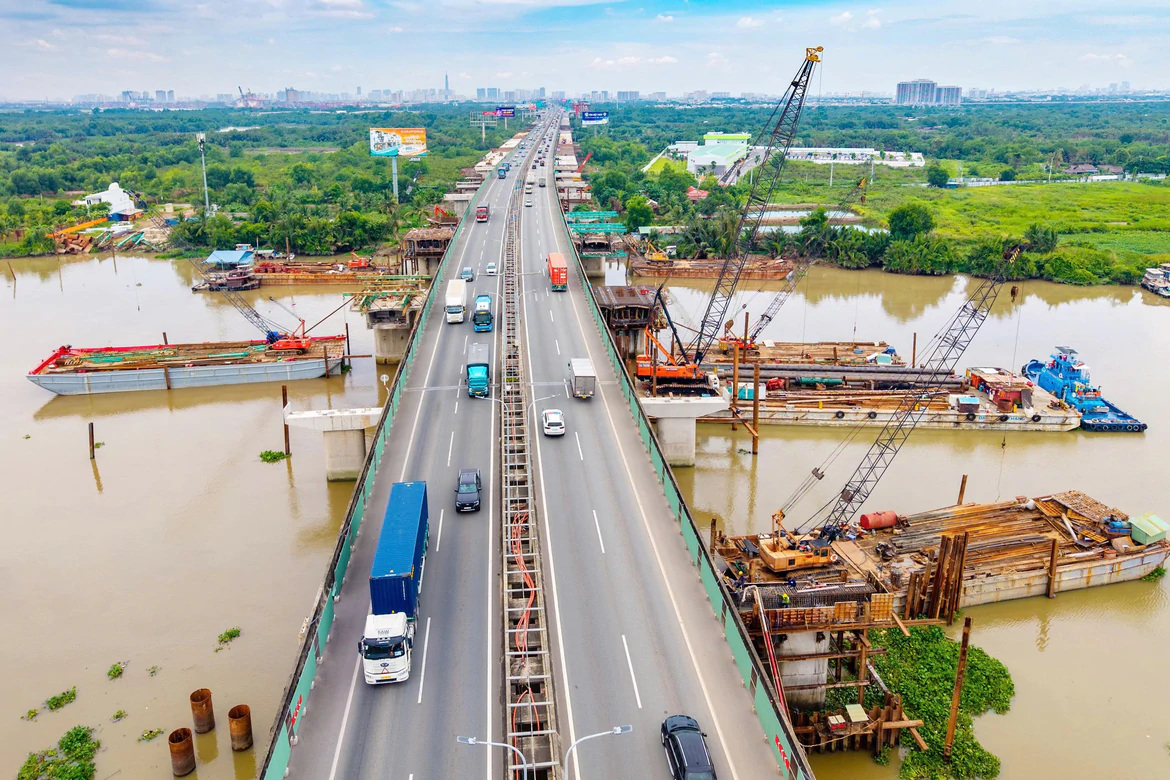 Công trường cầu và tuyến đường kết nối Long Thành, ô tô và xe tải lưu thông qua khu vực thi công mở rộng